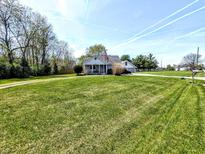 Charming home featuring a well-maintained lawn, mature trees, and an American flag at 3514 Carson Ave, Indianapolis, IN 46227