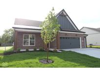 Charming brick home featuring a manicured lawn and attached two-car garage, enhancing curb appeal at 5052 Carmine St, Brownsburg, IN 46112