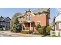 Charming brick home featuring a landscaped front yard and architectural details on a sunny day at 902 N College Ave, Indianapolis, IN 46202