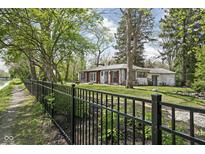 Exterior of home with an iron fence and tree lined street at 157 E 61St St, Indianapolis, IN 46220