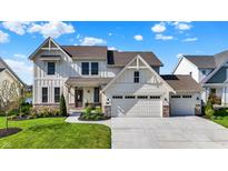 Charming two-story home with a manicured lawn, stone accents, and a three-car garage at 180 Oakhurst Way, Westfield, IN 46074