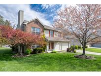 Charming two-story home boasting a lush lawn and mature trees in full bloom at 3611 Owster Ln, Indianapolis, IN 46237