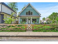 Charming two-story home featuring a decorative wooden fence and freshly manicured lawn at 401 Sanders St, Indianapolis, IN 46225