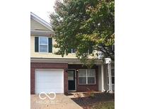 Two-story townhome featuring a brick facade, attached garage, and well-maintained landscaping in a desirable neighborhood at 4932 Tuscany Ln, Indianapolis, IN 46254