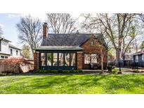 Charming brick home featuring a beautifully landscaped front yard and enclosed sunroom at 5331 N New Jersey St, Indianapolis, IN 46220