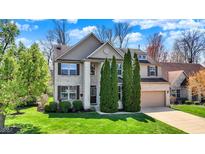 Two-story home with attached garage, well-maintained lawn, and tall evergreen trees in the front yard at 5549 Dill Ct, Indianapolis, IN 46237
