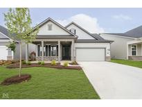 Charming home with landscaped yard, covered porch, and two-car garage offers great curb appeal at 5661 Stetson Dr, Whitestown, IN 46052