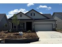 Charming single-story home with a two-car garage, gray siding and a well-manicured lawn in a desirable community at 5661 Stetson Dr, Whitestown, IN 46052