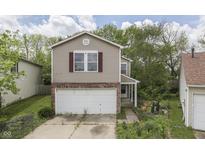 Charming two-story home featuring a front-facing two car garage and a well-manicured lawn at 6534 Redland Way, Indianapolis, IN 46217