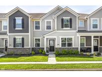 Charming townhome featuring stone accents, gray siding, black shutters, and a well-manicured front lawn at 7265 Governors Row, Avon, IN 46123