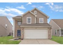 Charming two-story home featuring brick and siding, a two-car garage, and a well-manicured lawn at 7860 Sergi Canyon Dr, Indianapolis, IN 46217