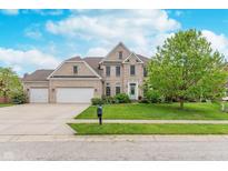 Charming two-story home featuring a brick facade, manicured lawn, and three-car garage at 8181 Fairway Dr, Brownsburg, IN 46112