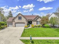 Charming single-story brick home with a three-car garage and beautifully landscaped front yard at 8324 Thorn Bend Dr, Indianapolis, IN 46278