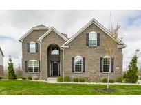 Stunning two-story brick home with manicured lawn and dark shutters against a cloudy sky at 8330 Dumfries Dr, Brownsburg, IN 46112