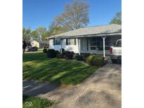 Charming one-story home with well-maintained lawn, tidy landscaping, and a convenient covered parking area at 929 Delman Dr, Shelbyville, IN 46176