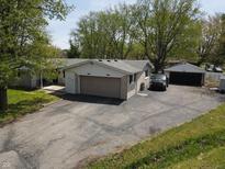Aerial view of a ranch-style house, an attached garage, a detached garage, and a spacious paved driveway at 1029 Price Rd, Avon, IN 46123
