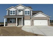 Two-story home featuring gray and brick exterior, a two-car garage and a well-lit white front door at 210 Aster Way, Greenfield, IN 46140