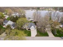 Aerial view of a home near a lake with mature trees and meticulous landscaping at 2428 Hawthorn Pl, Noblesville, IN 46062