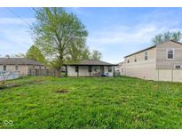 Spacious backyard featuring a well-maintained lawn and a covered patio, perfect for outdoor enjoyment at 2822 Walker Ave, Indianapolis, IN 46203