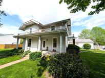 Charming two-story home with a covered front porch and landscaped yard, perfect for relaxation at 4335 River Rd, Columbus, IN 47203