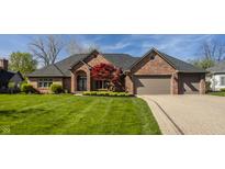 Charming brick home with manicured lawn, brick driveway, and two-car garage at 5872 Lake Kessler Ct, Indianapolis, IN 46226