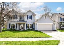 Charming two-story home with blue shutters, a well-manicured lawn, and an attached two-car garage at 6205 Albury Dr, Indianapolis, IN 46236