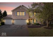 Charming brick home with three-car garage, blue shutters, and beautifully landscaped front yard at 6211 W Bayfront Shores, McCordsville, IN 46055