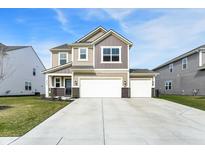 Two-story home featuring a three-car garage, tan siding, and a well-maintained lawn at 8583 Strabet Dr, Pendleton, IN 46064