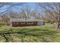 Charming brick ranch home featuring a well-maintained lawn, attached garage and inviting curb appeal at 10586 W School Pkwy, Carmel, IN 46280