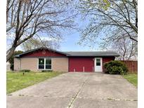 Inviting single-story home featuring a concrete driveway and a well-maintained front lawn with mature trees at 1221 S Catherwood Ave, Indianapolis, IN 46203