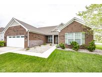 Charming brick home featuring a manicured lawn, two-car garage, and inviting walkway at 14014 Fieldcrest Dr, McCordsville, IN 46055