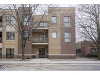 Modern multi-story condo building with brick and siding facade and upper level balcony at 233 E Saint Joseph St # 2G, Indianapolis, IN 46202