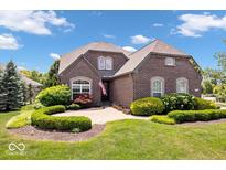 Charming brick home with well-manicured front yard, lush greenery, and beautiful landscaping at 2705 April Springs View, Carmel, IN 46074