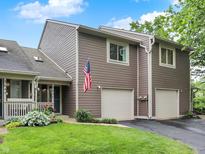 Charming two-story home with an attached two-car garage, American flag, and well-maintained landscaping at 3646 Beach Blvd, Cicero, IN 46034