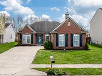 Charming brick home with a well-manicured lawn, blue door and shutters, and concrete driveway at 4729 Beach Club Dr, Noblesville, IN 46062