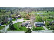 Aerial view of a home with a well-maintained lawn, mature trees, and a circular driveway at 4977 Beechwood Rd, Avon, IN 46123