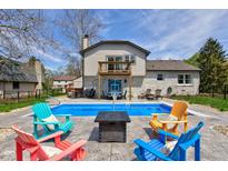 Inviting backyard oasis with a refreshing pool, lounge chairs, and a cozy fire pit at 4977 Beechwood Rd, Avon, IN 46123