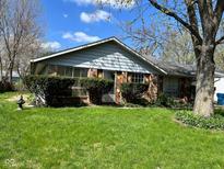 Charming single-story home with mature trees, lush lawn, and well-maintained landscaping in a suburban setting at 6040 Ipswich Ct, Indianapolis, IN 46254