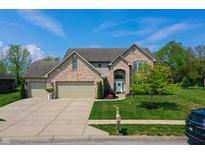 Charming two-story brick home with a three-car garage and well-manicured lawn at 6054 Easy Ln, Indianapolis, IN 46259