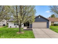 Charming home with blue siding, neutral garage door, and a beautifully landscaped front yard at 6159 Connie Ct, Indianapolis, IN 46237