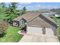 Lovely brick home featuring an attached two-car garage and blossoming landscaping at 6232 Buck Trail Rd, Indianapolis, IN 46237