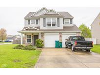 Charming two-story home featuring neutral siding, brick accents, two-car garage and well-maintained lawn at 6376 Matcumbe Way, Plainfield, IN 46168
