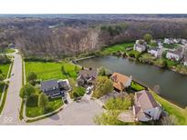 Stunning aerial view of homes around a serene pond surrounded by lush greenery and mature trees at 6514 Trevia Ct, Indianapolis, IN 46236