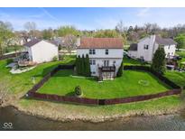 Beautiful backyard with a wooden deck, a fenced lawn and views of the pond at 6514 Trevia Ct, Indianapolis, IN 46236
