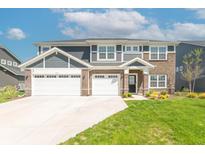 Beautiful two-story home with a three-car garage, brick accents, and a well-manicured lawn at 7144 Hart St, Cumberland, IN 46229