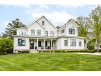 Stunning white modern farmhouse with a welcoming front porch and manicured lawn at 7602 N Pennsylvania St, Indianapolis, IN 46240