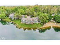 Stunning lakefront property with lush greenery and a private beach, offering a serene and picturesque living environment at 7786 Harbour Isle, Indianapolis, IN 46240