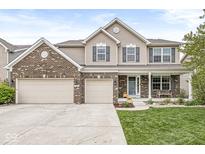 Charming two-story home featuring a three-car garage, brick accents, and a welcoming front porch at 7829 Hedgehop Dr, Zionsville, IN 46077