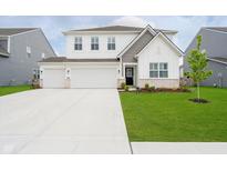 Charming two-story home with a well-manicured lawn and a spacious three-car garage at 8654 Tripp Rd, Pendleton, IN 46064