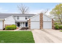 Charming townhouse with well-maintained lawn and attached two-car garage in a residential neighborhood at 9467 Sandpiper W Dr, Indianapolis, IN 46268
